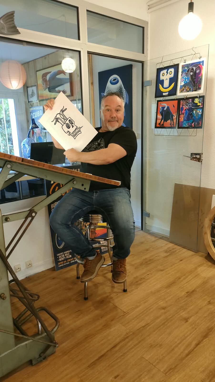 Marc Cluzet présentant une illustration dans son atelier